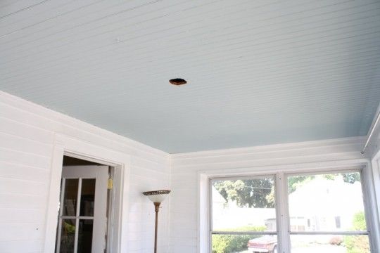 an empty room with white walls and wood flooring on the ceiling, has a large window in front of it