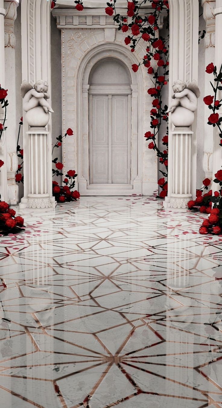 a white building with red flowers on the ground in front of it and a door