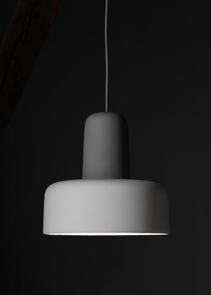 a white light hanging from a ceiling in a dark room