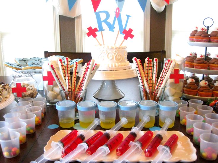 the dessert table is set up with cupcakes and candy sticks in plastic cups