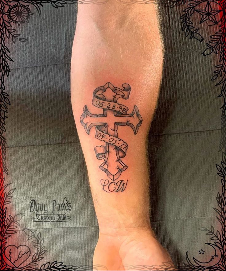 a person with a tattoo on their arm that has an anchor and cross in it