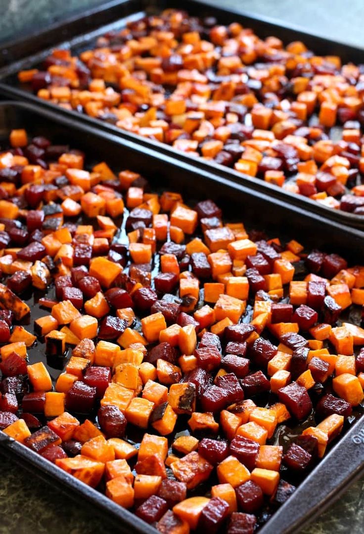 two pans filled with sweet potatoes on top of a table