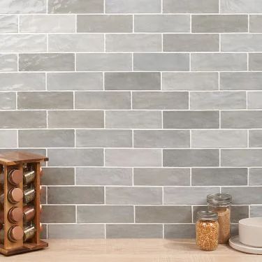 a kitchen counter with jars and spices on it, next to a wooden block wall