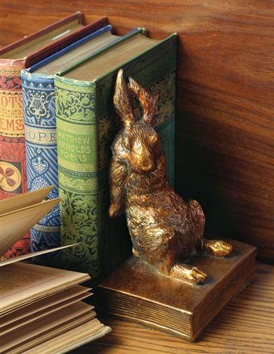 a golden rabbit figurine sitting next to books