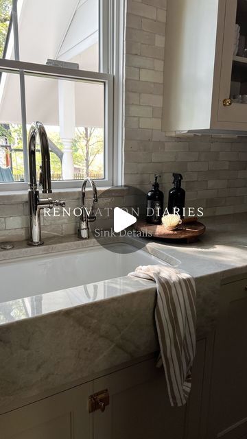 a white kitchen sink sitting under a window