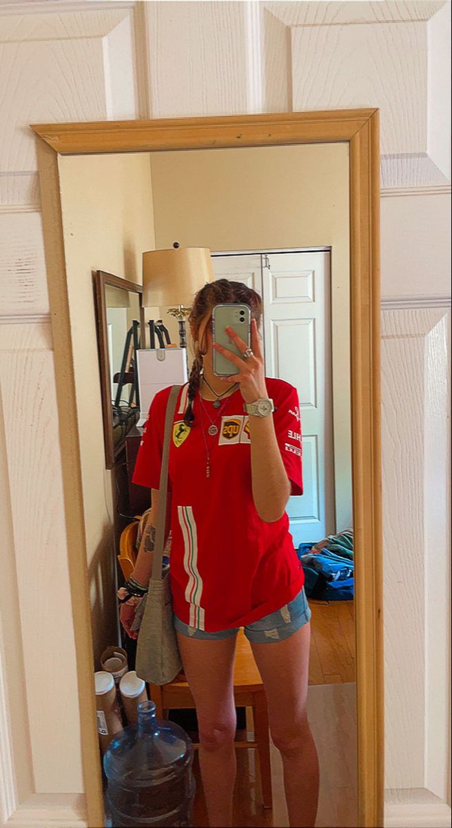 Ferrari’s Formula 1 team shirt and jean shorts. Paired with a tan crossbody bag. Afternoon in Florida Ferrari Tshirt Outfit, Ferrari Merch Outfit, Ferrari Shirt Outfit, Ferrari Outfit, Ferrari Tshirt, Ferrari T Shirt, Ferrari Shirt, F1 Girl, Ferrari Girl