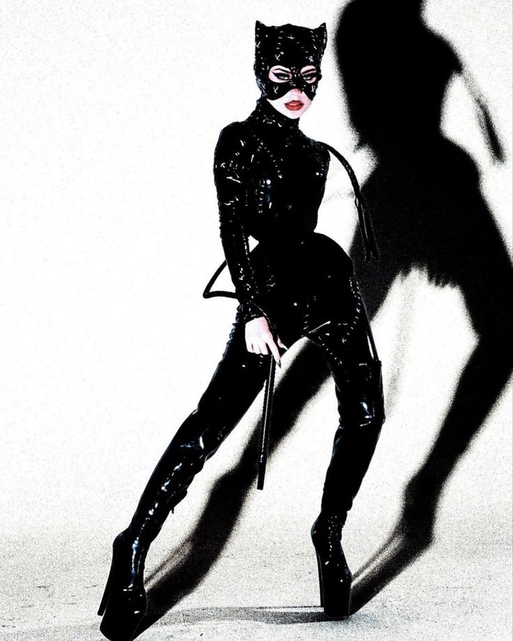 a woman in catwoman costume standing next to a shadow