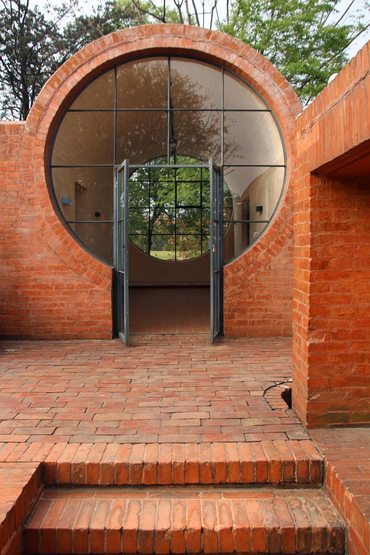 the entrance to a brick building with an arched glass door and steps leading up to it