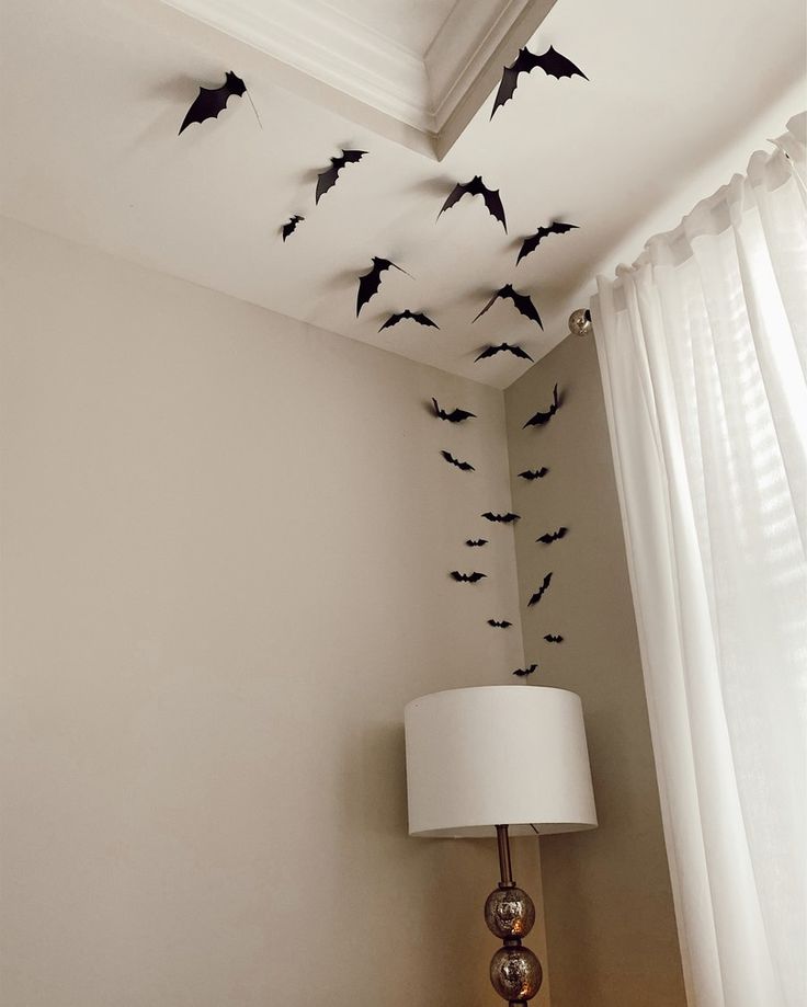 bats are flying in the air above a lamp