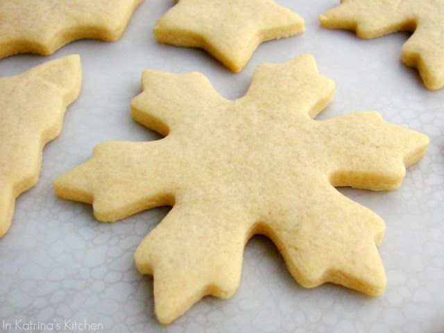 some cut out cookies sitting on top of a white tablecloth with snowflakes