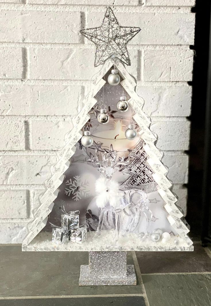 a white christmas tree with silver ornaments on it