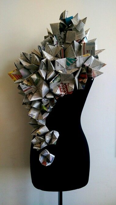 a black mannequin with lots of newspapers on it's head and neck