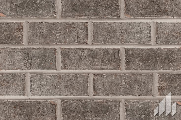 a brick wall that is made out of grey bricks and has an arrow painted on it