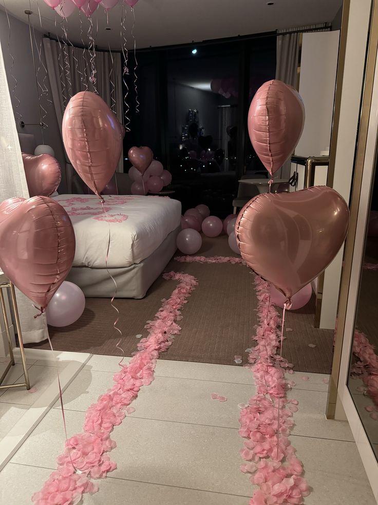 pink balloons and streamers in the shape of hearts are on display at a party