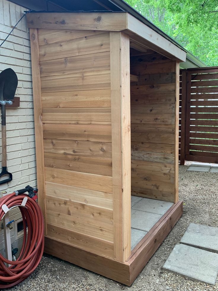 a wooden shed with a hose attached to it