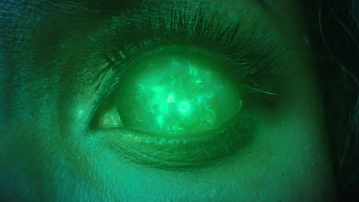 an eye with green light shining through it