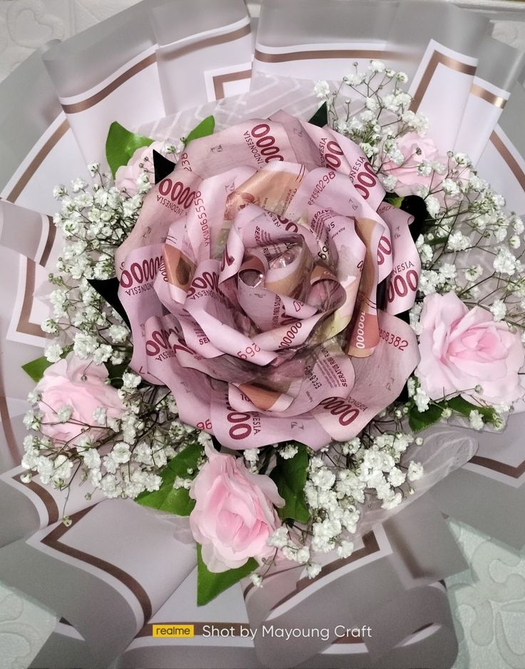 a bouquet of pink flowers and baby's breath wrapped in paper