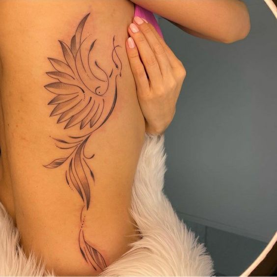 a woman with a bird tattoo on her back