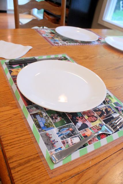 plates and utensils sitting on top of a wooden table with photos in them