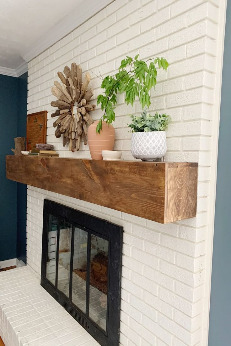 a white brick fireplace with potted plants on the mantel and shelf above it