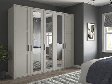 a bedroom with grey walls and white furniture