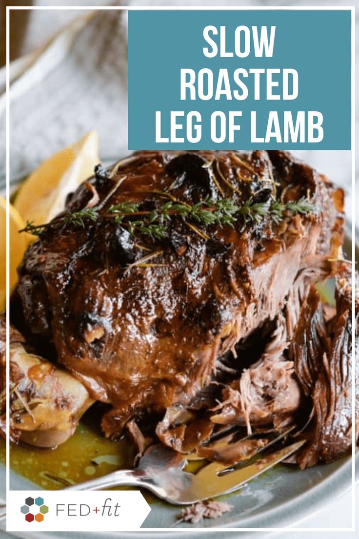 slow roasted leg of lamb on a plate with lemon wedges