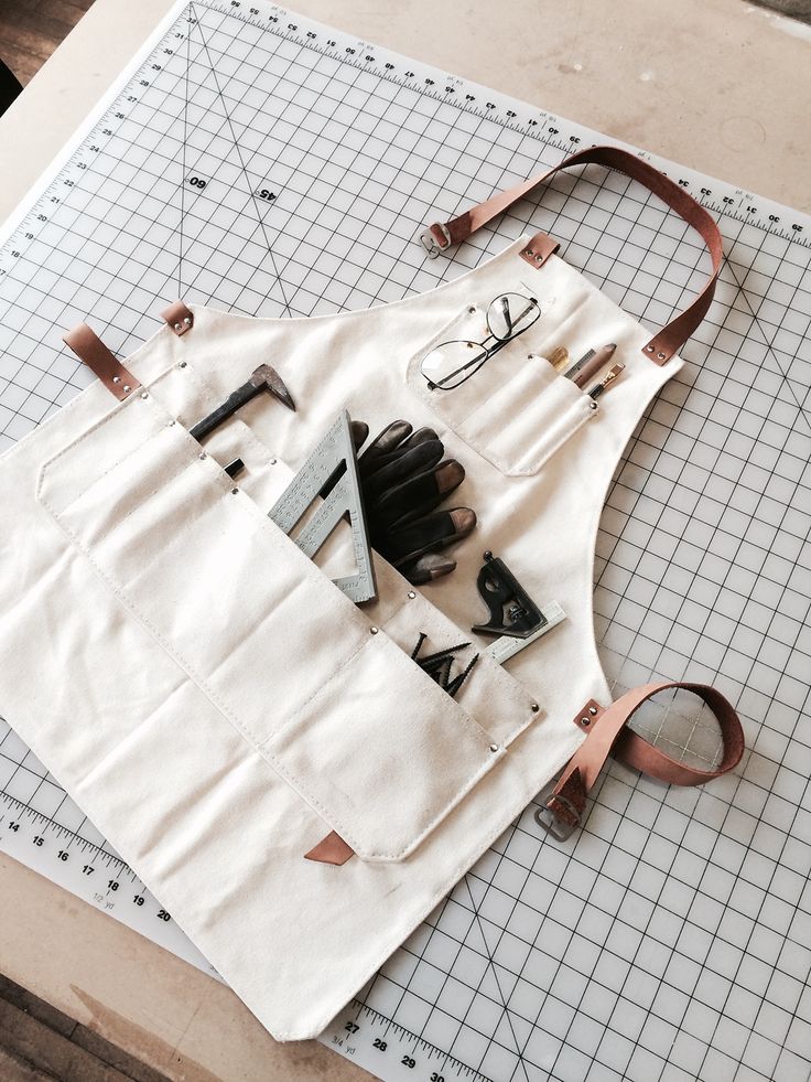 a white bag sitting on top of a cutting board with scissors and other items in it