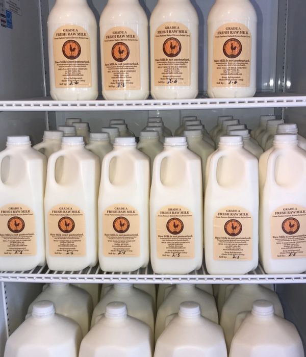 several bottles of milk on shelves in a store