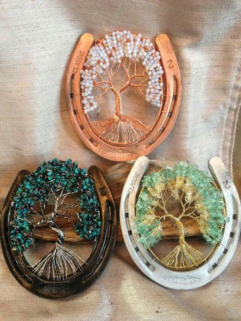 three wooden brooches with trees on them sitting on a cloth covered tablecloth