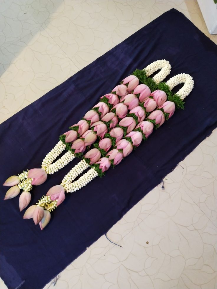 flowers arranged in the shape of letters on a blue tablecloth with white and pink tulips