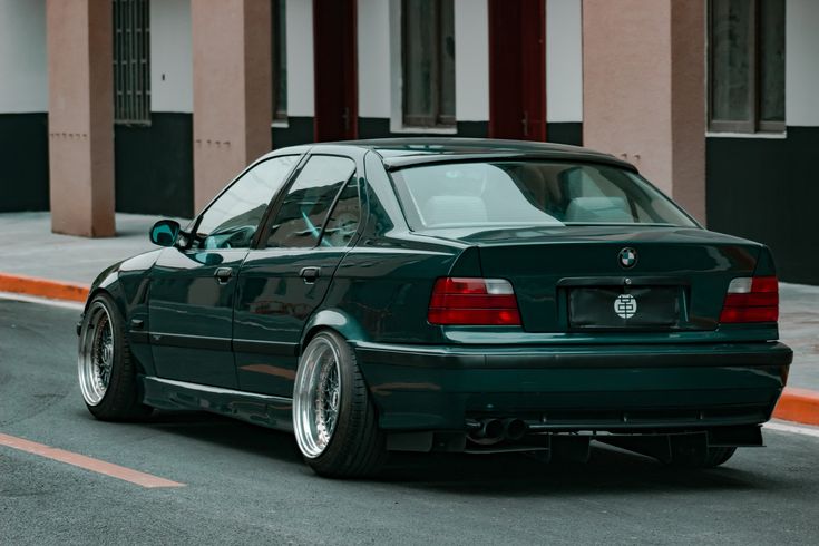 a green car is parked on the street