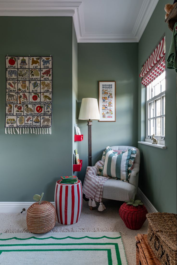 a living room with green walls and striped rugs on the floor next to a chair