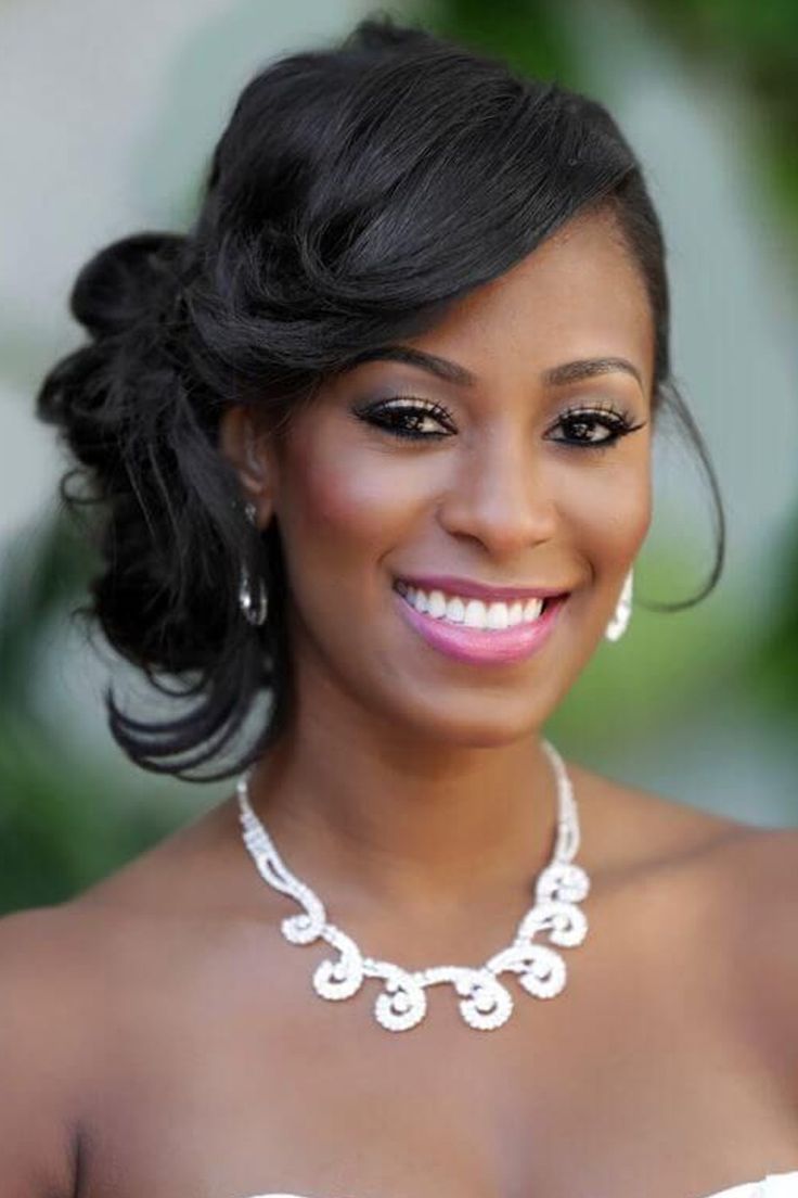 a woman in a white dress wearing a necklace and earrings on her neck smiling at the camera