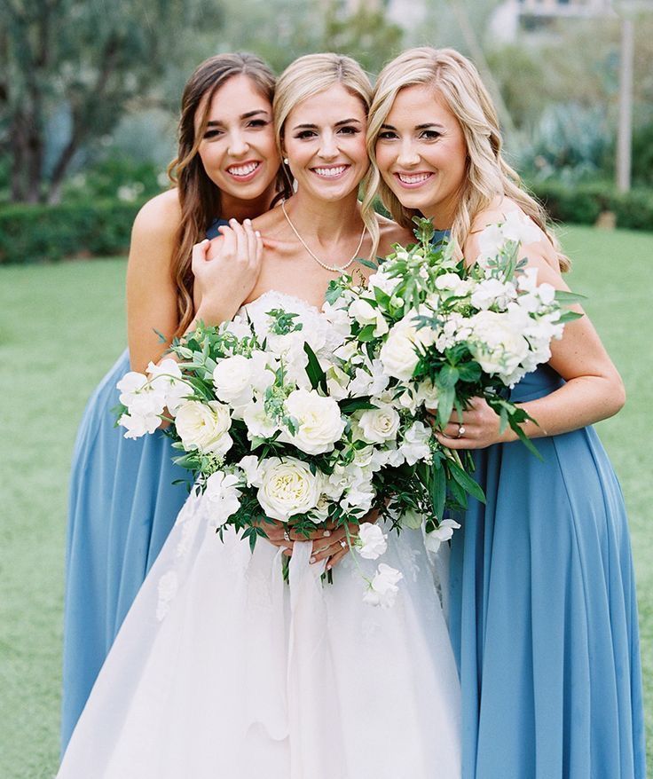 three bridesmaids pose for a photo with their bouquets