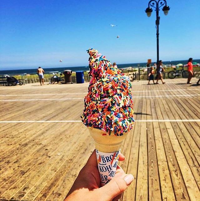 an ice cream cone filled with sprinkles on top of a wooden floor