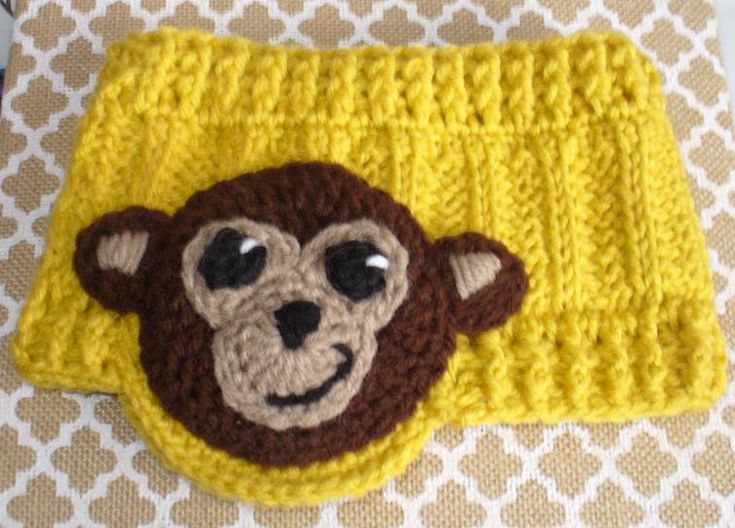 a crocheted monkey head on top of a yellow blanket