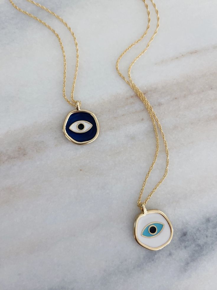 This evil eye necklace is made by hand with enamel in white. Hangs from a 16” double chain 14k gold plated Sustainably sourced materials FINAL SALE Eye Pendant Necklace, Evil Eye Necklace Gold, Eye Pendant, Necklace White, Evil Eye Pendant, Double Chain, Themed Jewelry, Evil Eye Necklace, Creative Jewelry