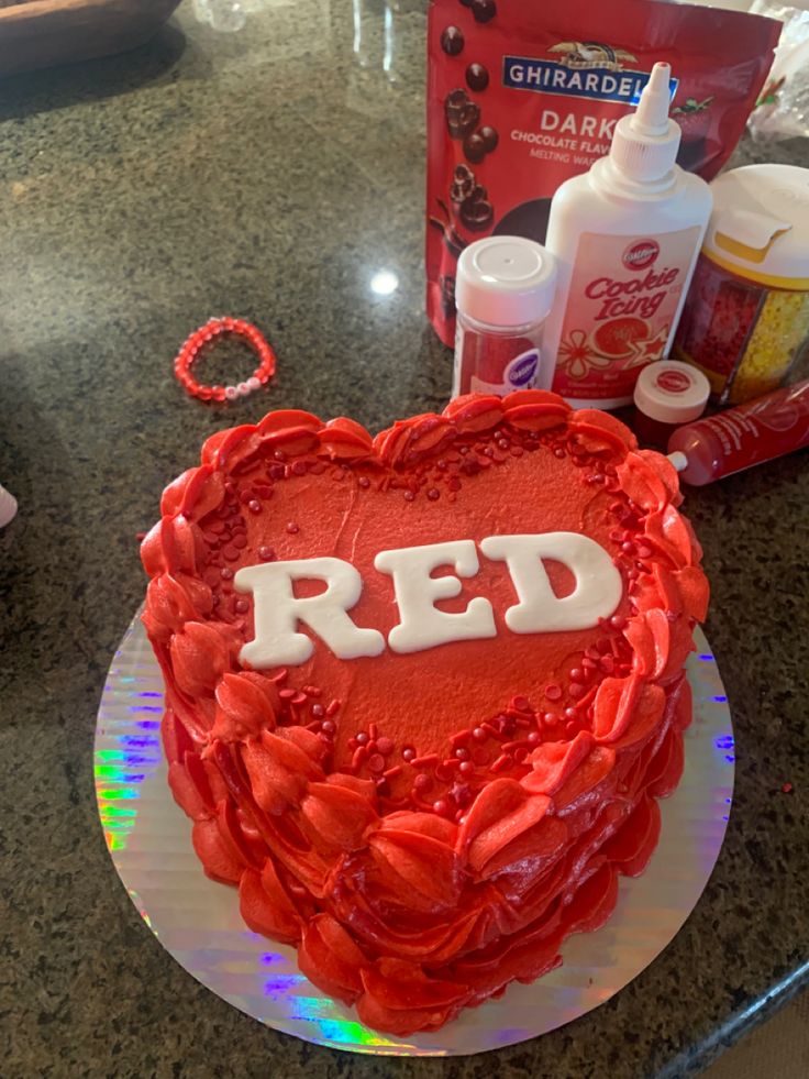 a heart shaped cake sitting on top of a counter next to bottles and condiments