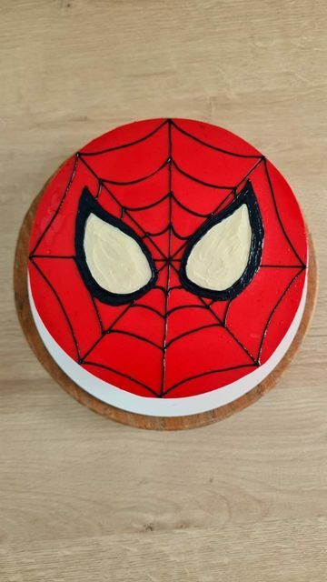 a spiderman cake on a wooden table