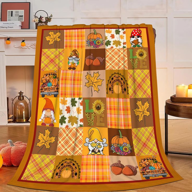 an orange and yellow quilt on the floor next to pumpkins, candles and other decorations