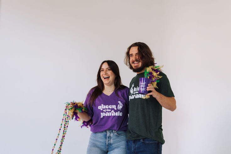 a man and woman standing next to each other holding confetti sticks in their hands