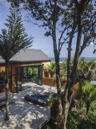 the deck is surrounded by trees and has an outdoor living area that overlooks the ocean