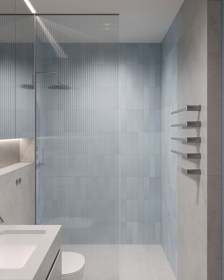 a bathroom with a glass shower door next to a sink