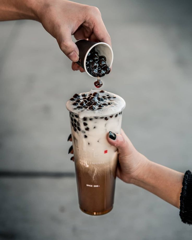 a person pouring coffee into a cup with chocolate sprinkles on the top