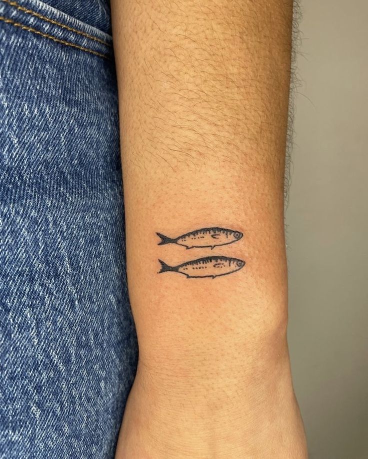 two fish tattoo on the wrist