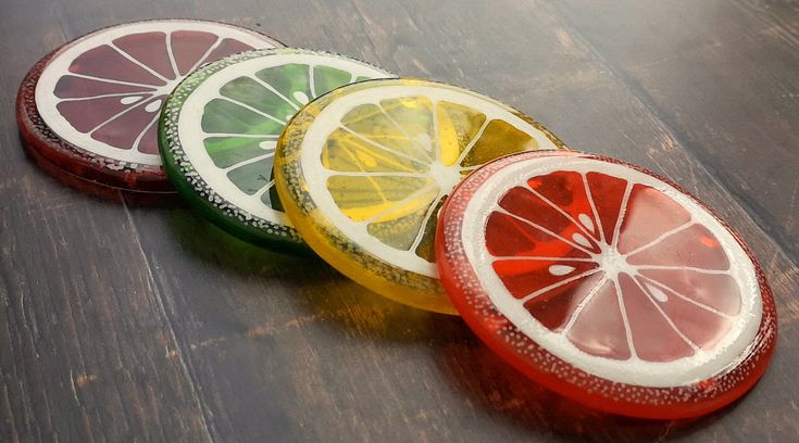 four slices of lemon, lime, and grapefruit sitting on a table top