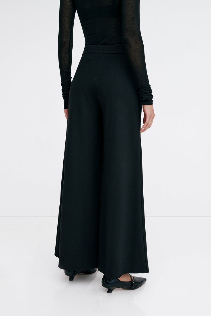 Claremont does all the legwork to keep your Monday-Sunday wardrobe polished. These relaxed wide-leg pants are fashioned from structured European ponte with a fly-front zipper and a wide waistband that rests comfortably at the mid-waist. Finished with functional pockets and a tuxedo panel to accentuate her clean lines. | Astrid, in black and in mist, is 5'9" (175 cm) tall, wearing size XS. Sejal, in black, is 5'8" (173 cm) tall, wearing size M. Approximately 39.5" (10.5 cm) from below the belt. Inseam is approximately 30" (76 cm). European Ponte, also known as Punto di Roma (60% Viscose, 30% Polyamide, 10% Lycra).Machine wash on delicate cycle, or hand wash in cold water. Tumble dry on low heat, or for best results, lay flat to dry. Designed in NYC. Handcrafted in Europe. | Marcella Claremo Modern Wide Leg Pants For Evening In Fall, Versatile Formal Full Length Wide Leg Pants, Modern Full Length Wide Leg Pants For Evening, Versatile Wide Leg Pants For Evening In Spring, Versatile Wide Leg Pants For Spring Evening, Versatile Evening Wide Leg Pants For Spring, Modern Full-length Wide Leg Pants For Fall, Modern Full Length Wide Leg Pants For Fall, Full Length Culottes For Work