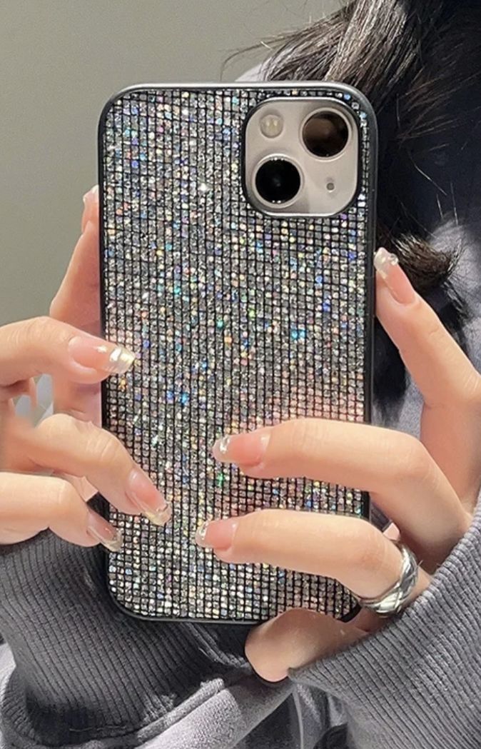 a woman holding up her phone case in front of her face