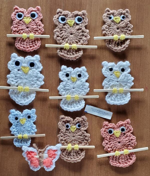 several crocheted owls are sitting on clothes pins with toothpicks in them