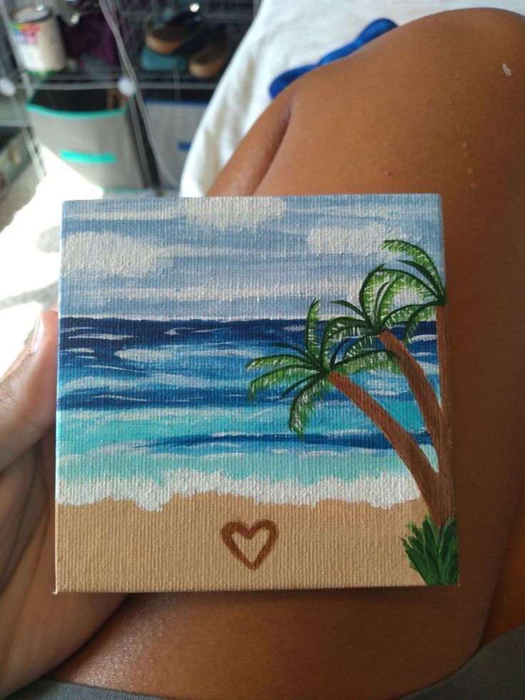 a painting of a beach scene with a heart in the sand and palm trees painted on it